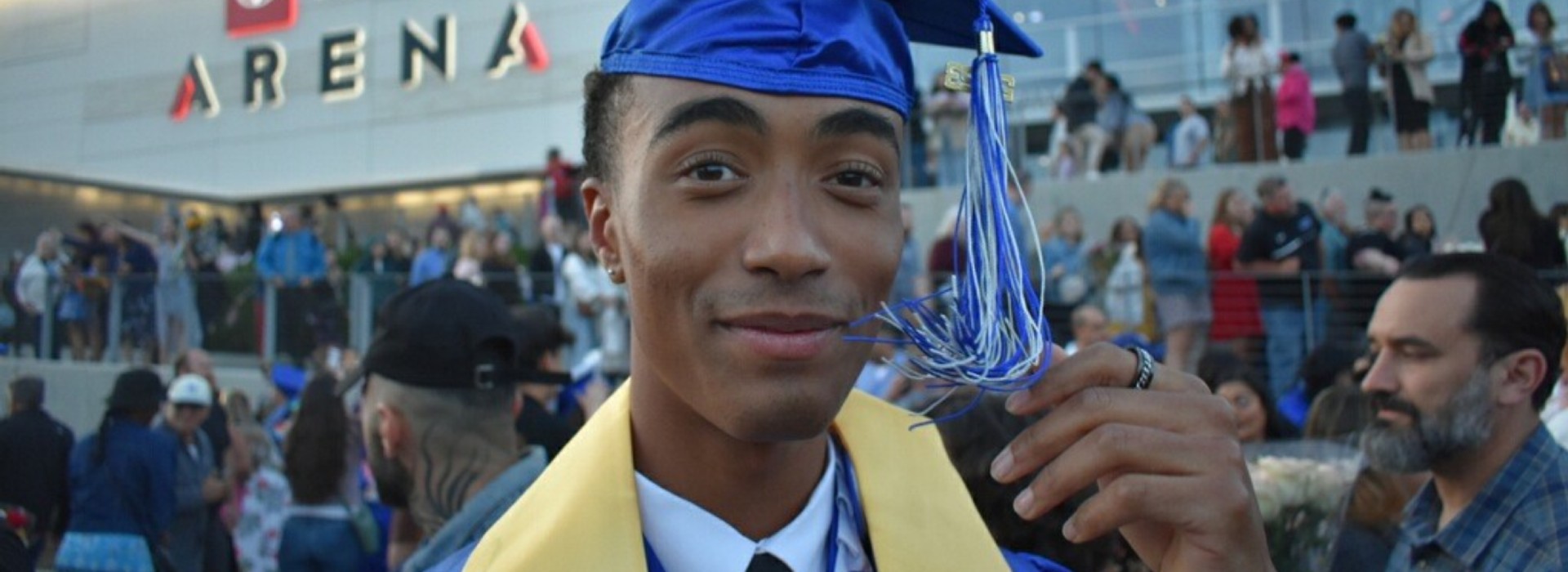 A young man in a graduation cap and gown.
