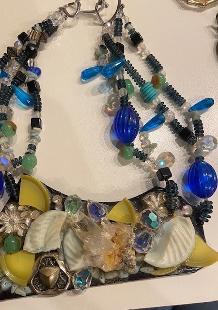A necklace with blue and yellow beads on it.