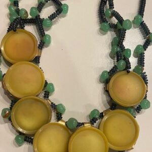 A necklace with yellow beads and green beads.