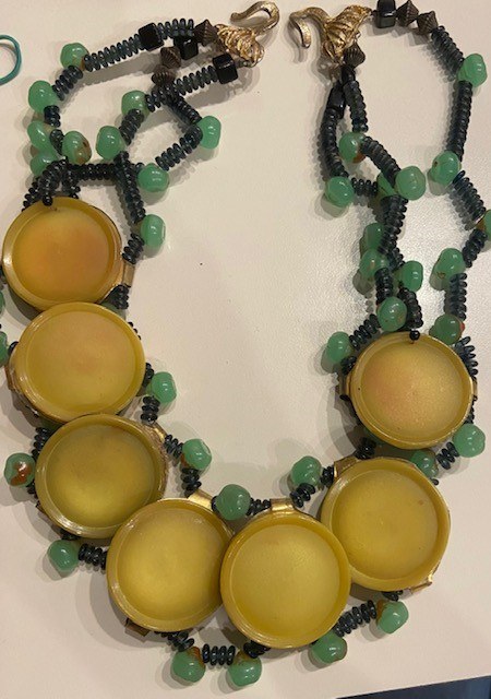 A necklace with yellow beads and green beads.