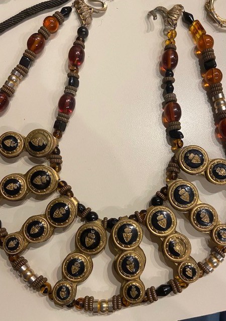 A necklace with a black and brown bead on it.