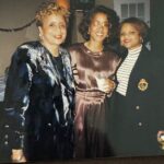 Three women standing next to each other at a party.