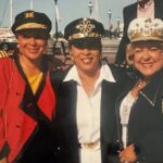 Three women in hats standing next to each other.