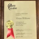 Vivian williams receives a certificate of appreciation from the opera carolina.
