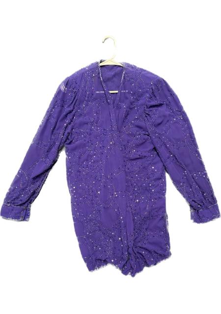 A purple blouse with sequins on it.