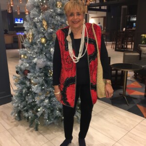 A woman standing in front of a christmas tree.