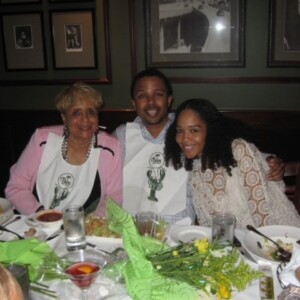 Three people posing for a picture at a dinner table.