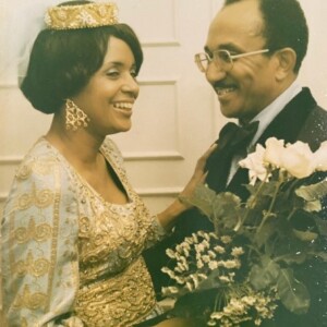 An old photo of a man and woman holding flowers.