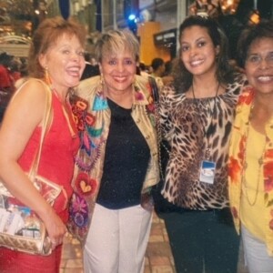 Four women posing for a picture at an event.