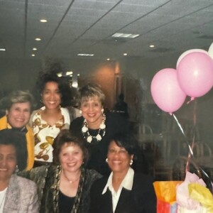 A group of women posing for a photo with balloons.