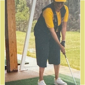 A picture of a woman playing golf on a tee.
