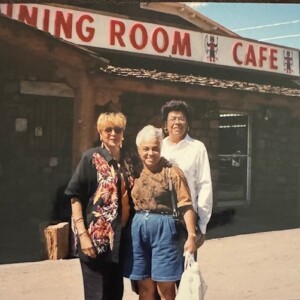 Three women standing in front of a dining room cafe.