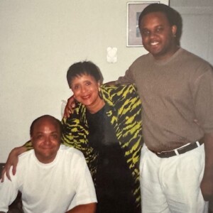 Three people posing for a picture in a living room.
