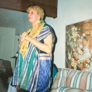 A woman standing in a living room holding a microphone.