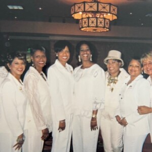 A group of women dressed in white posing for a picture.