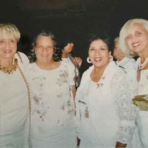 A group of women dressed in white posing for a photo.