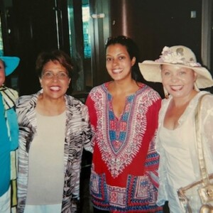 Three women in hats posing for a photo.