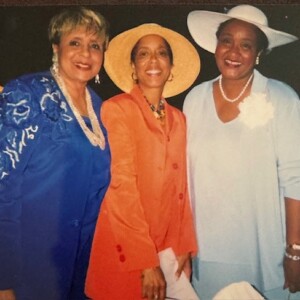 Three women posing for a photo with hats on.