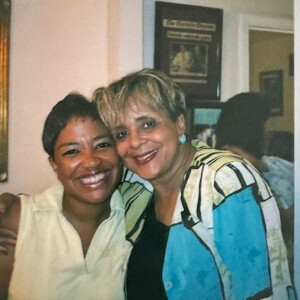 Two women posing for a photo in a living room.