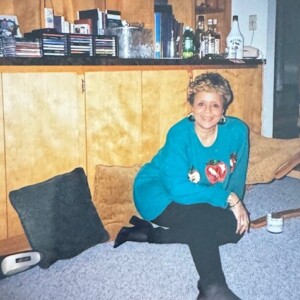 A woman sitting on the floor in a living room.