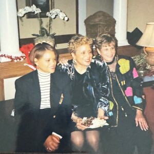 Three women posing for a picture in front of a christmas tree.