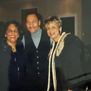 Three people posing for a picture at a party.
