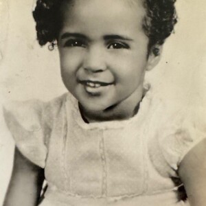 An old photo of a little girl with curly hair.
