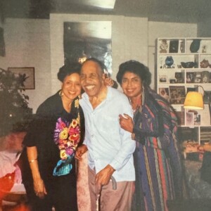 Three people standing next to each other in a living room.