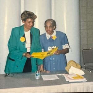 Two women standing next to each other at a table.