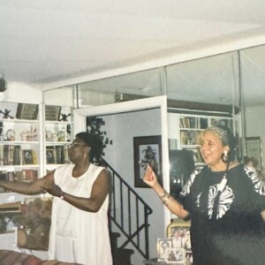 Two women standing in a living room.