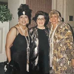 Three women in flapper dresses posing for a photo.