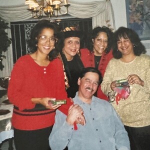 A group of people posing for a picture in front of a christmas tree.