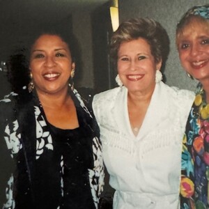 Three women posing for a photo with one another.