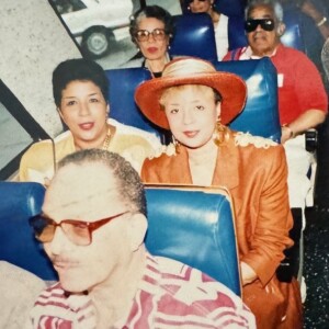 A group of people sitting on a bus with hats on.