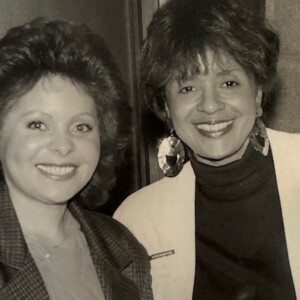Two women posing for a photo in an old black and white photo.