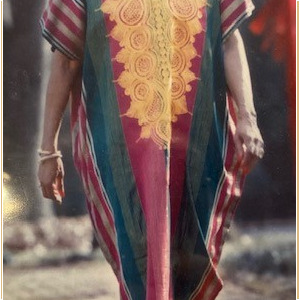 A woman in a colorful dress walking down a brick path.