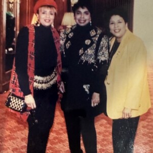 Three women standing next to each other in a room.