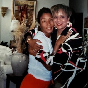 Two women hugging each other in a living room.
