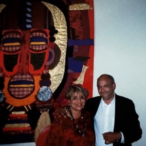 A man and woman standing in front of a large painting.