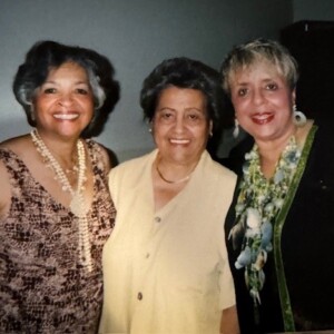Three women posing for a picture in a room.