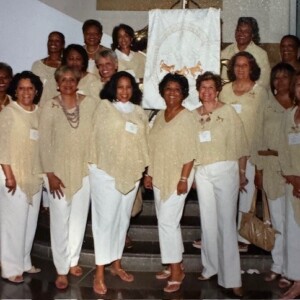 A group of women in white posing for a picture.