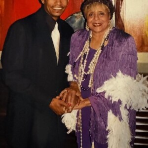 A woman in a purple dress standing next to a man in a suit.