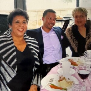 Three people posing for a picture at a table.