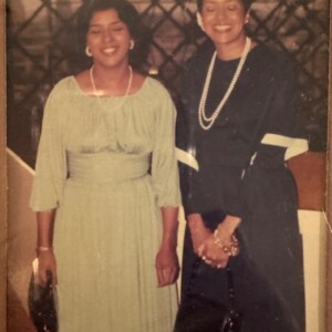 Two women in dresses standing next to each other.