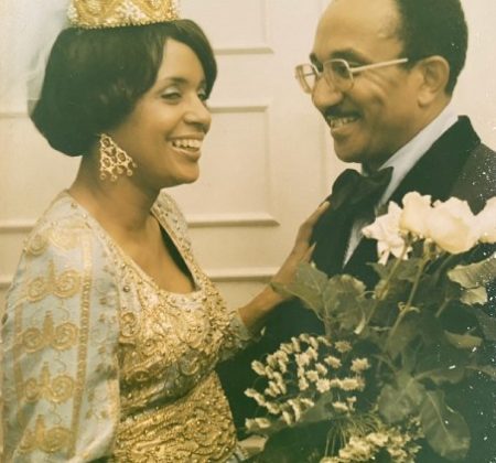 An old photo of a man and woman holding flowers.